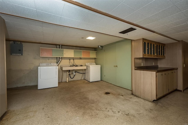 finished below grade area featuring independent washer and dryer, a sink, and electric panel