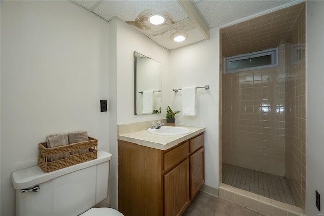 full bathroom featuring vanity, tile patterned flooring, toilet, and tiled shower
