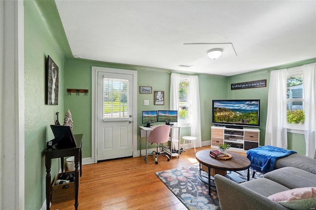 living area featuring baseboards, wood finished floors, and visible vents