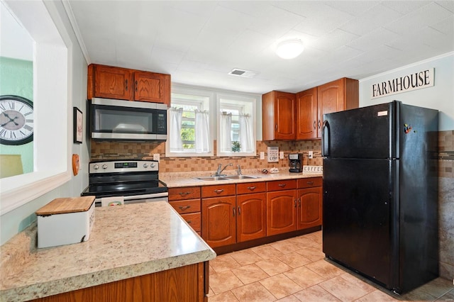 kitchen with a sink, appliances with stainless steel finishes, decorative backsplash, and light countertops