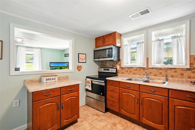 kitchen with a sink, light countertops, stainless steel appliances, decorative backsplash, and visible vents