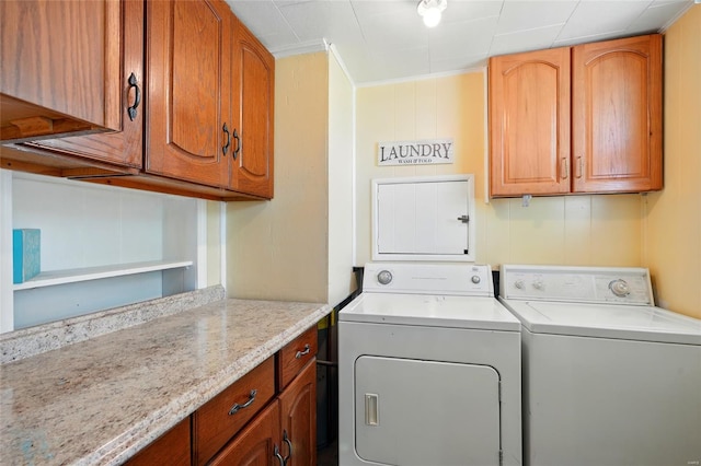 clothes washing area featuring crown molding, cabinet space, and independent washer and dryer