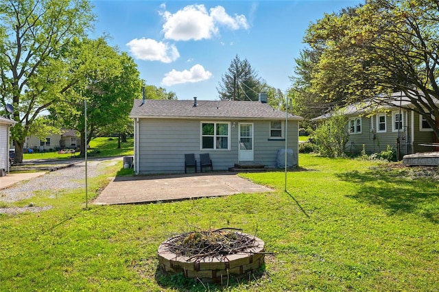 back of house featuring a yard, a fire pit, and a patio area