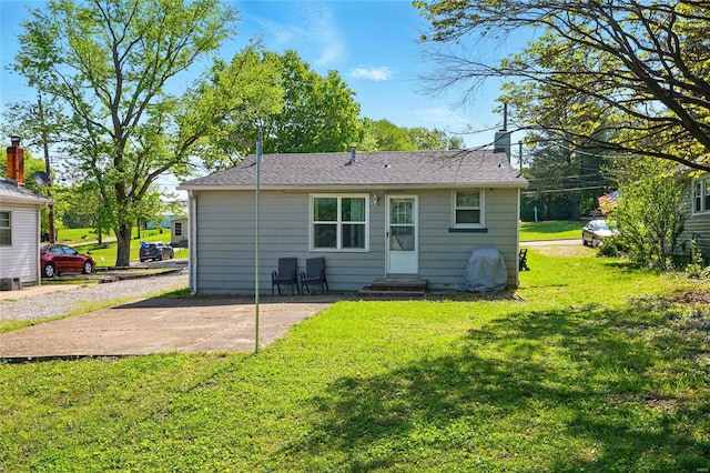 rear view of house featuring a lawn, a patio, a chimney, and entry steps