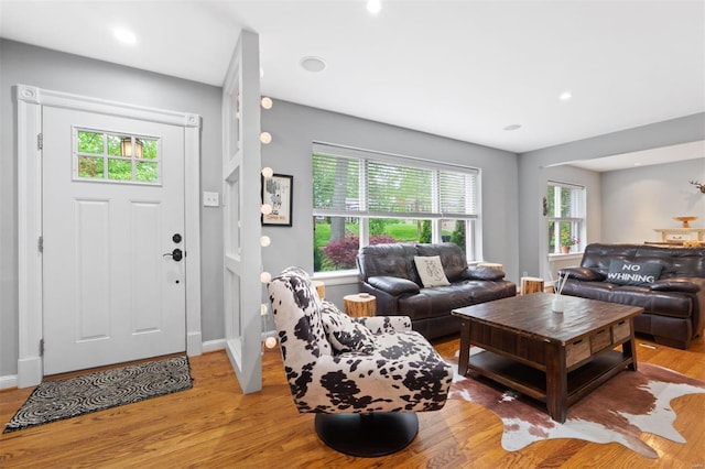 living area featuring baseboards, a wealth of natural light, light wood-style floors, and recessed lighting