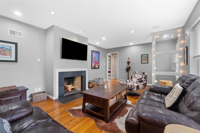 living area featuring visible vents, wood finished floors, a fireplace, and recessed lighting