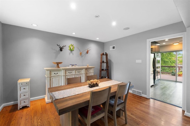 dining space with light wood-type flooring, visible vents, and recessed lighting