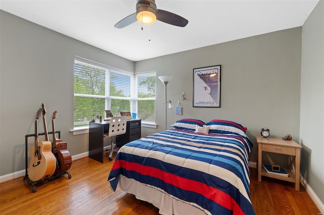 bedroom featuring a ceiling fan, wood finished floors, and baseboards