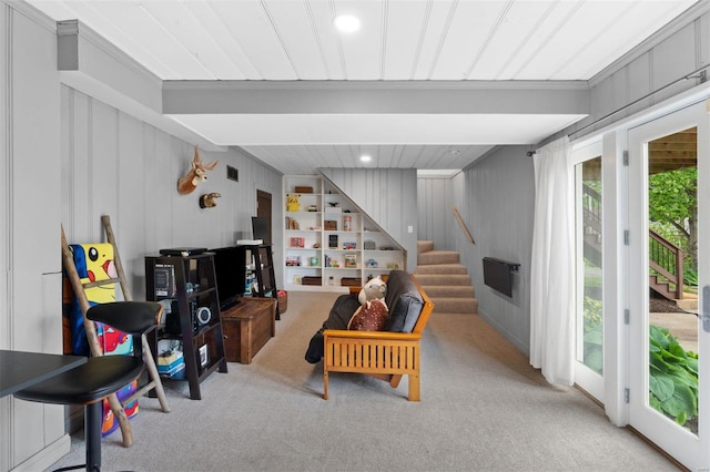 carpeted living area featuring stairs, wooden walls, recessed lighting, and visible vents