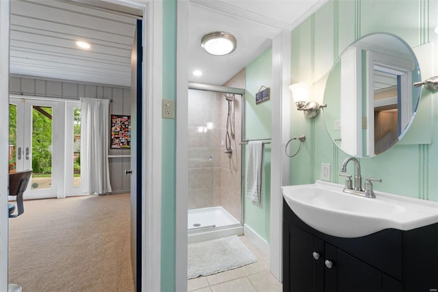 bathroom with vanity, tile patterned floors, crown molding, a shower stall, and baseboards