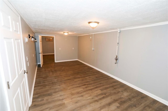 basement with a textured ceiling, baseboards, and wood finished floors