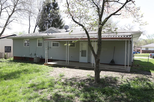back of property with a lawn and fence