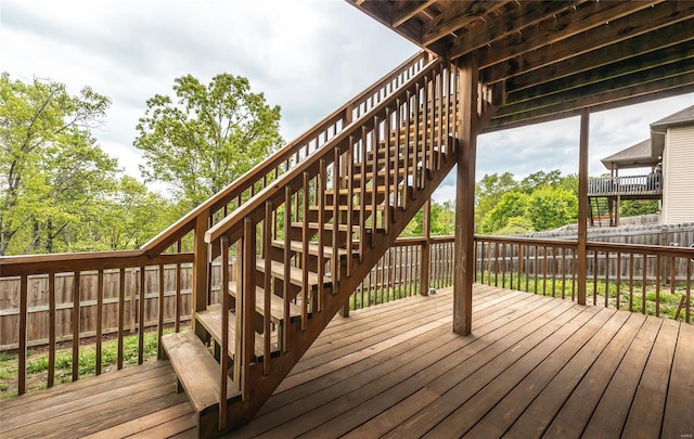 deck with a fenced backyard and stairway