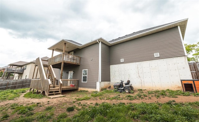 back of property with fence and a wooden deck