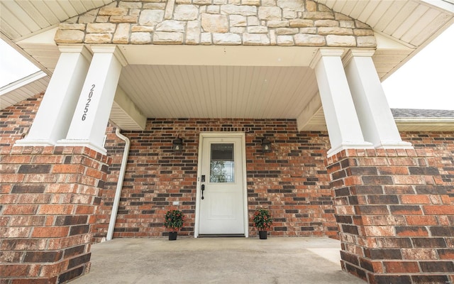 doorway to property featuring brick siding