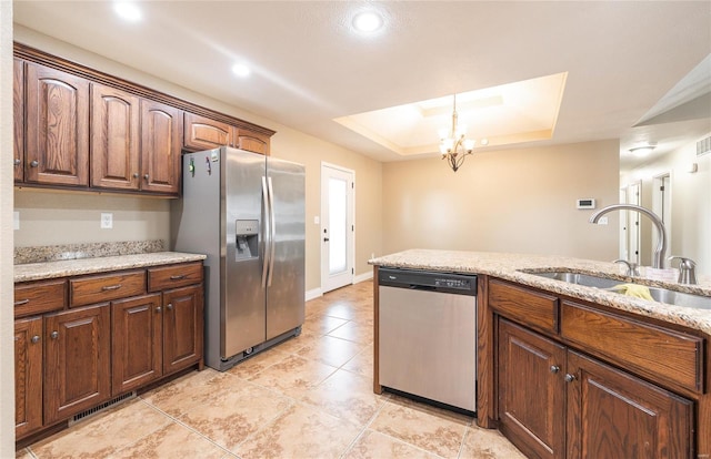 kitchen featuring visible vents, a sink, a raised ceiling, an inviting chandelier, and stainless steel appliances