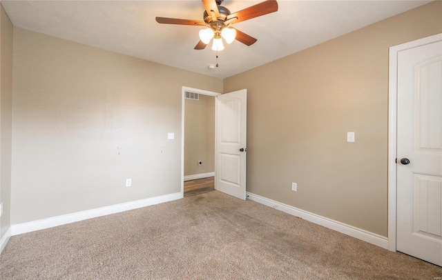 unfurnished bedroom with a ceiling fan, baseboards, visible vents, and carpet