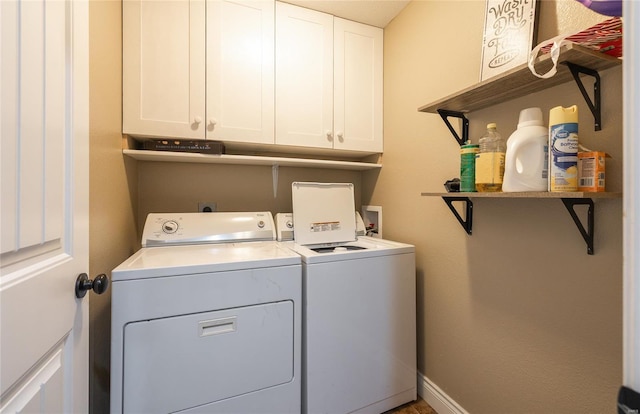 laundry area featuring baseboards, cabinet space, and washing machine and clothes dryer