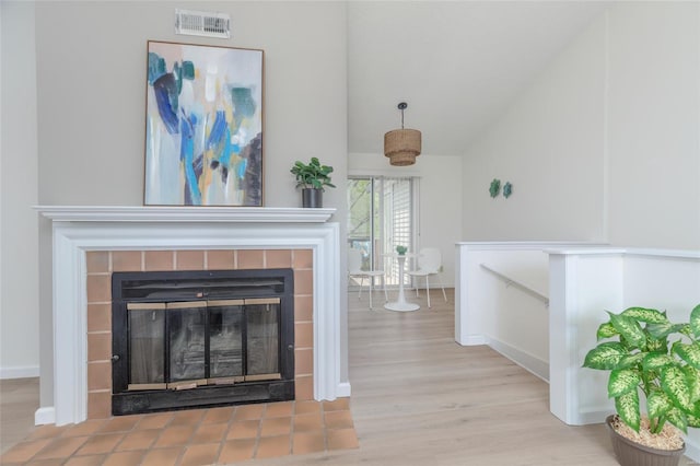room details featuring baseboards, wood finished floors, visible vents, and a fireplace
