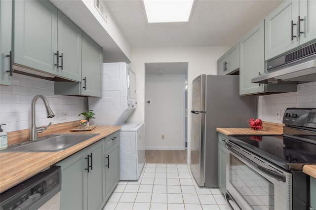 kitchen featuring decorative backsplash, stacked washer / dryer, stainless steel electric range, a sink, and dishwasher