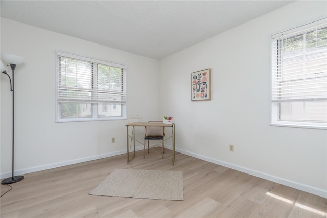 office area with baseboards and light wood-style flooring