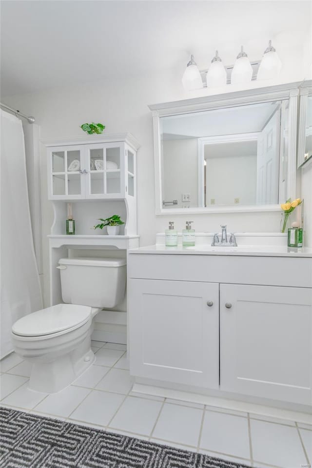 bathroom featuring toilet, a shower with shower curtain, tile patterned flooring, and vanity