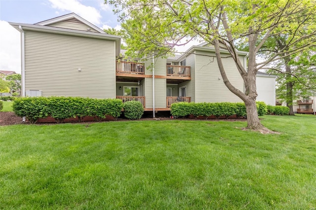 rear view of property featuring a lawn