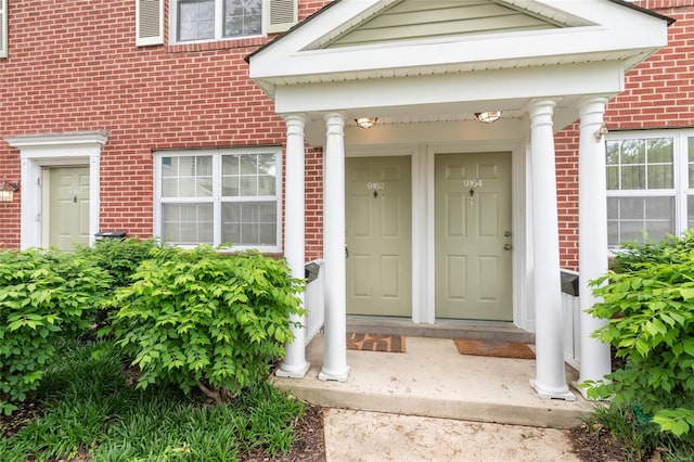 entrance to property featuring brick siding