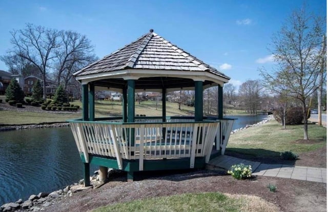 surrounding community with a water view, a gazebo, and a yard