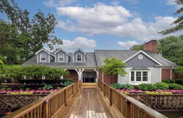 back of property featuring board and batten siding, a chimney, and brick siding