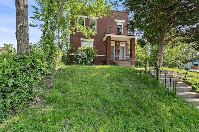 view of front of home featuring brick siding and a balcony