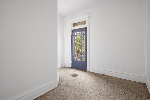 entrance foyer with baseboards, visible vents, and light carpet
