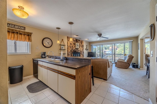 kitchen with open floor plan, a sink, a peninsula, and dishwasher