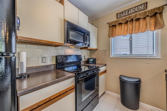 kitchen with dark countertops, baseboards, tasteful backsplash, light tile patterned floors, and black appliances