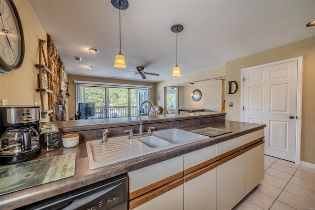 kitchen featuring pendant lighting, dark countertops, white cabinets, a sink, and dishwasher