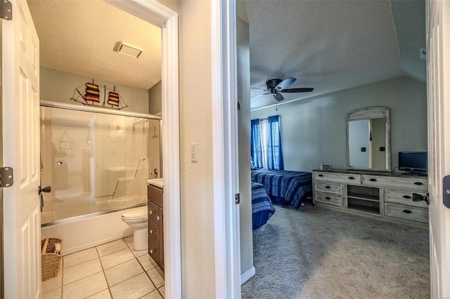 ensuite bathroom with vanity, ceiling fan, tile patterned floors, and shower / bath combination with glass door