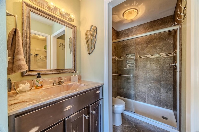 bathroom featuring vanity, toilet, tile patterned floors, and a stall shower