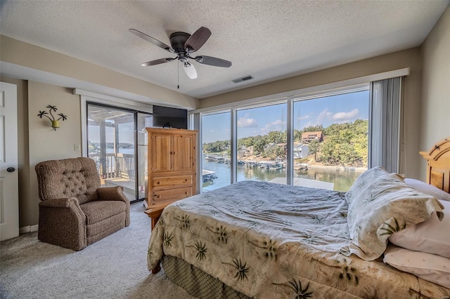 bedroom with visible vents, carpet, multiple windows, and access to exterior
