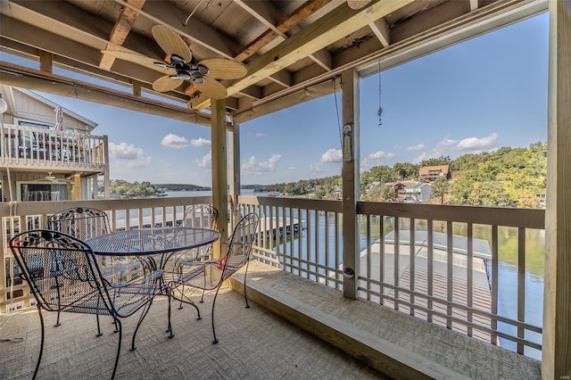 balcony with a water view and ceiling fan