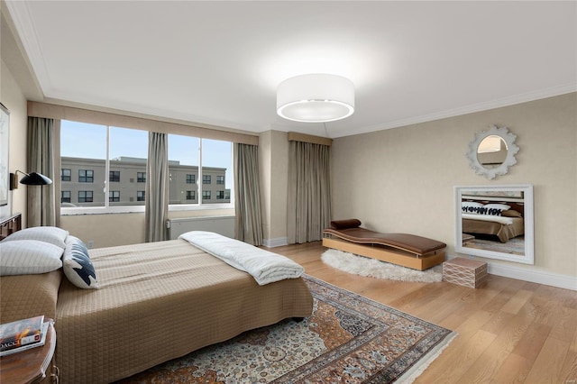 bedroom featuring crown molding, baseboards, and light wood-style flooring