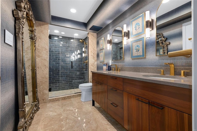 bathroom with a sink, a shower stall, toilet, and double vanity