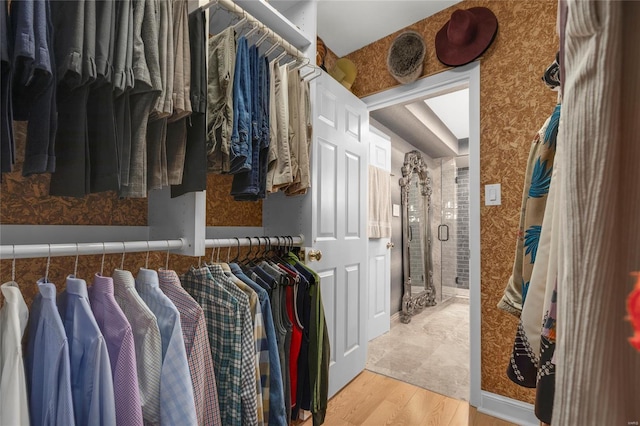walk in closet with wood finished floors