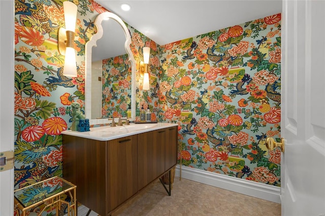 bathroom with recessed lighting, wallpapered walls, baseboards, and vanity