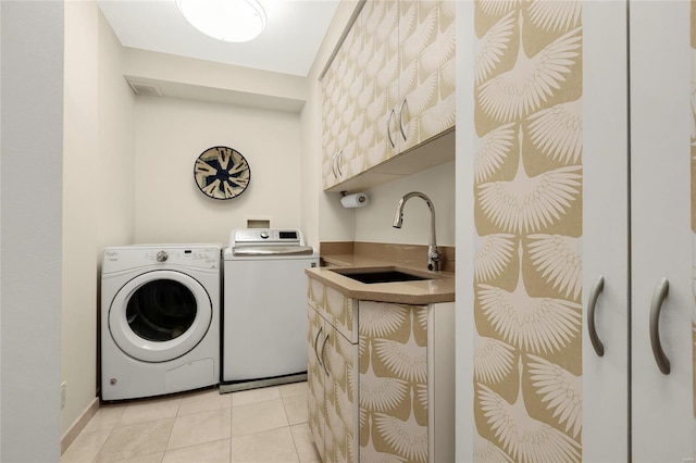 laundry room with cabinet space, light tile patterned flooring, a sink, indoor wet bar, and washing machine and dryer