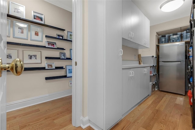corridor with baseboards and light wood-style flooring