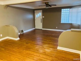 entrance foyer with ceiling fan, baseboards, wood finished floors, and visible vents