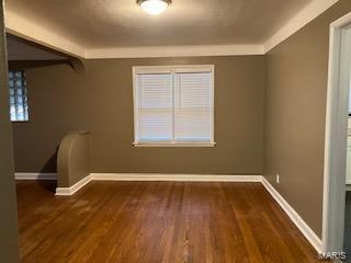 unfurnished room featuring baseboards and wood finished floors