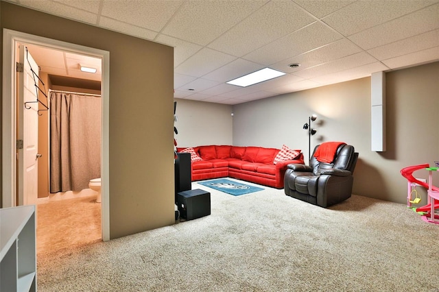 carpeted living room featuring a drop ceiling