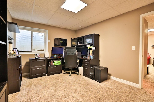carpeted home office featuring baseboards and a paneled ceiling