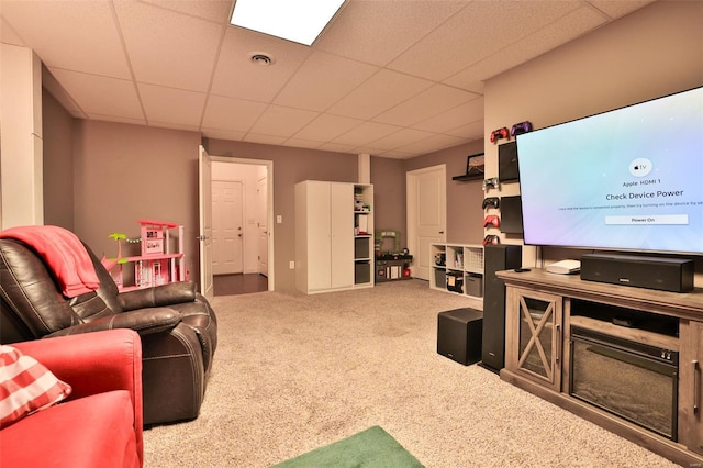 carpeted living room with a drop ceiling